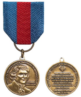 Blue ribbon with middle red strip suspending a bronze medal with Thomas Jefferson's image; reverse side notes, NSSAR Essay Contest Scholarship Supporter with a Jefferson quote