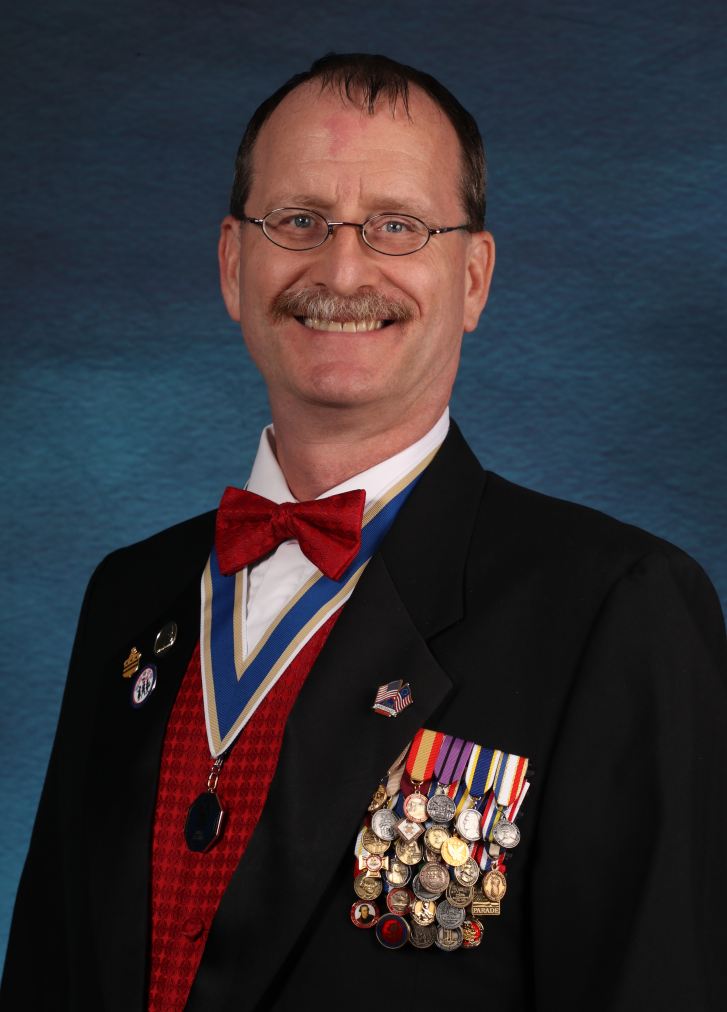 Virginia SAR President Darrin Schmidt, in dark business suit with SAR medals